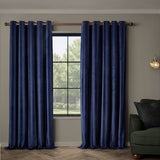 Regency Stripe velvet eyelet curtains in Midnight navy, fully lined with grommet top, hung either side of a window in a living room with a dark green sofa.