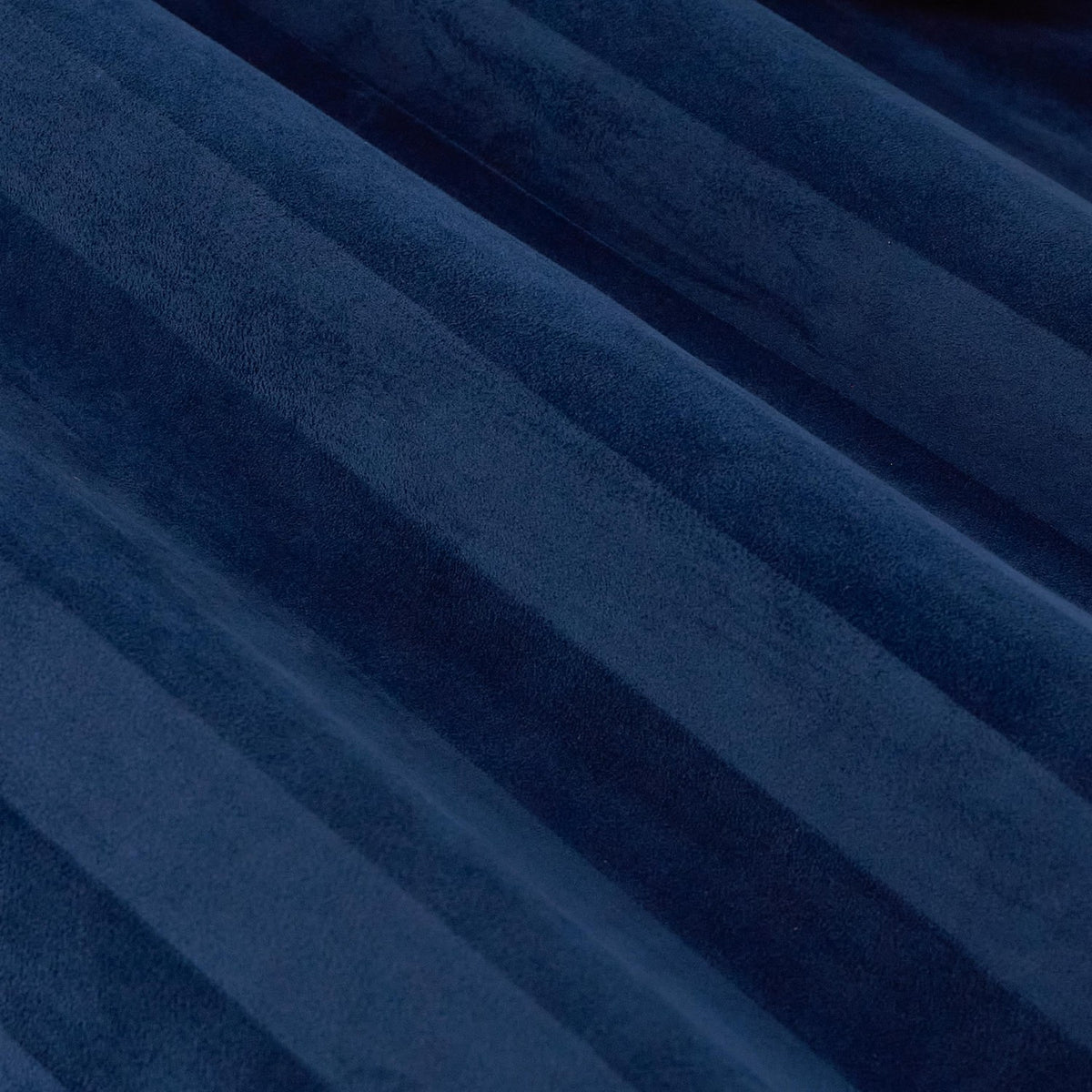 Close-up of Regency Stripe eyelet curtains in Midnight, showing soft-pile velvet with subtle vertical stripes creating light and dark navy tonal shifts.
