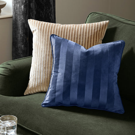 Regency Stripe Jacquard Velvet Cushion in midnight blue with tonal woven stripes, shown on a green sofa beside a beige ribbed cushion.