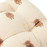 Rhighco Linen Cotton Seat Pad in natural cream, close-up of tufted cotton slub fabric printed with highland cows and yellow flowers.
