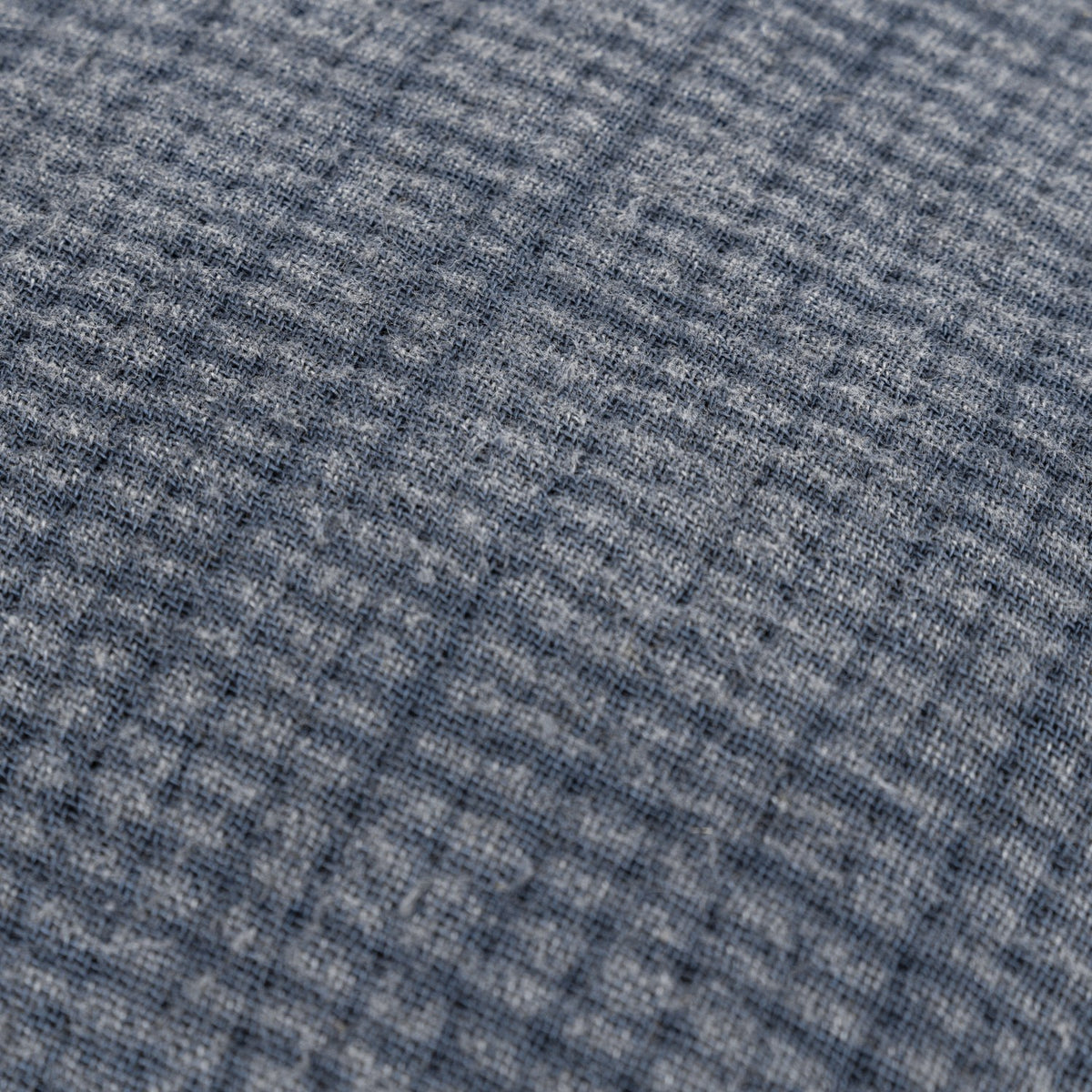Close-up of the Ribble Reversible Cotton Cushion in ink blue, showing a finely ribbed woven cotton texture with subtle grid-like lines.