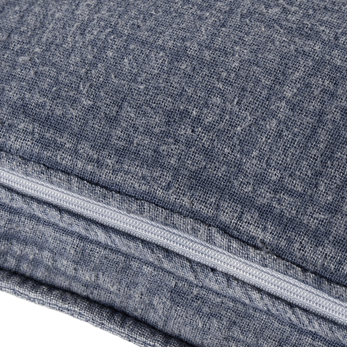 Close-up of the Ribble Reversible Cotton Cushion in ink blue, showing woven ribbed texture and a concealed zip along the seam edge.