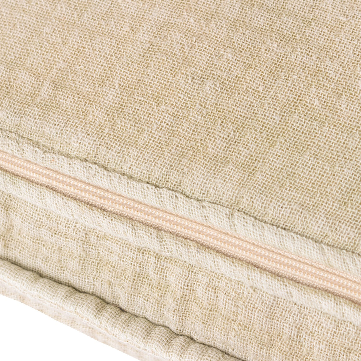 Close-up of the Ribble Reversible Cotton Cushion in natural, showing textured woven cotton fabric with a peach zip closure along one edge.