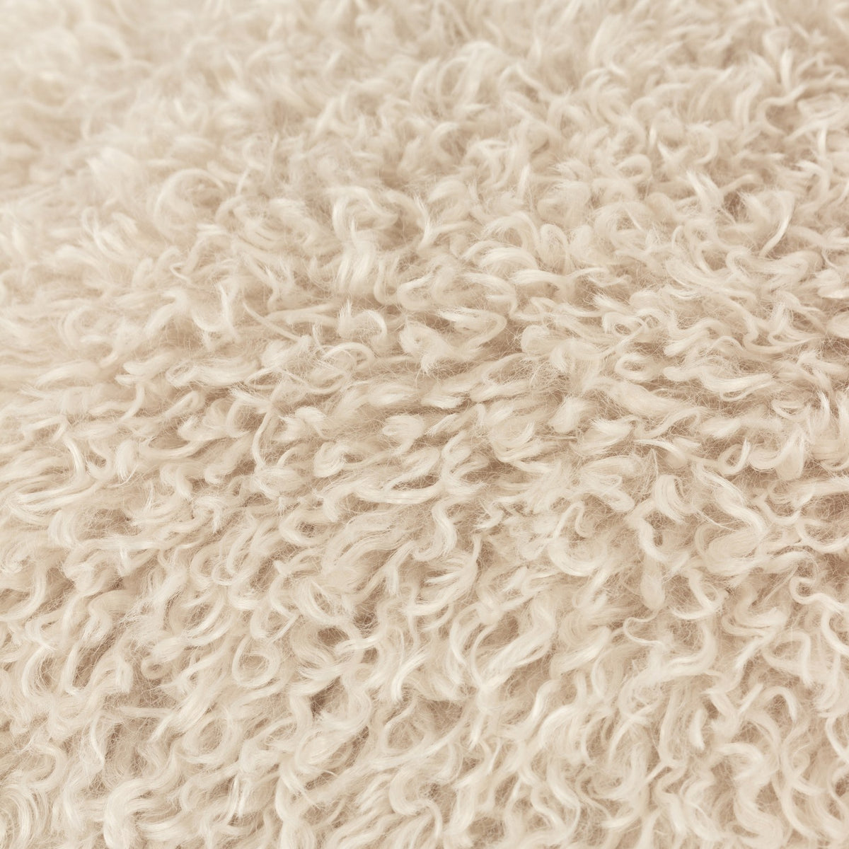 Close-up of the Rowan Faux Fur Polyester Velvet Cushion in natural cream, showing its shaggy, curly-pile texture reminiscent of Mongolian sheepskin.