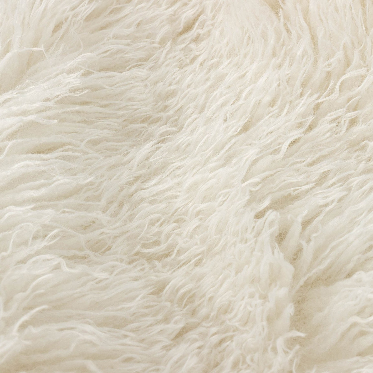 Close-up of the Rowan Faux Fur Plain Velvet Throw in ecru, showing the shaggy faux Mongolian fur texture in soft off-white cream.