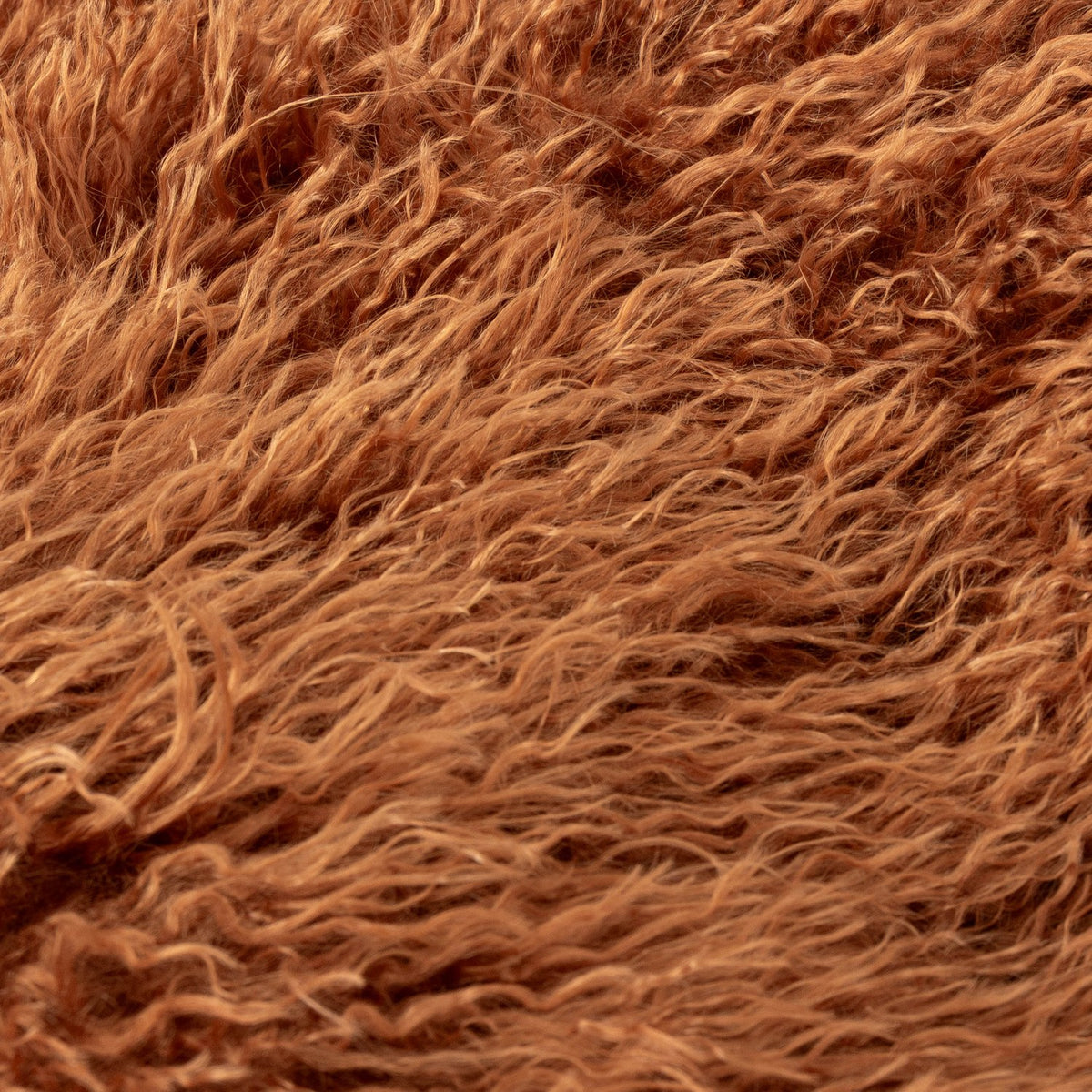 Close-up of the Rowan Faux Fur Plain Velvet Throw in ginger, showing long-pile shaggy faux Mongolian fur strands in a warm rust tone.
