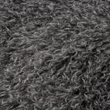 Close-up of the Rowan Faux Fur Throw in grey, showing deep curly Mongolian-style fur with mottled charcoal tones and silvery tips.