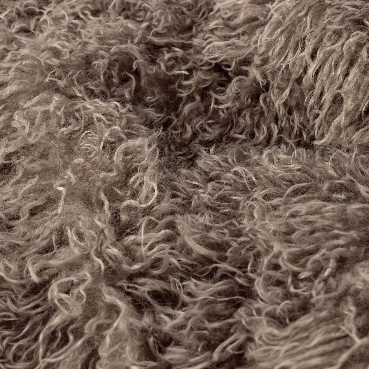 Close-up of the Rowan Faux Fur Throw in mocha, showing the long-pile, curled shaggy fur texture on the front face.