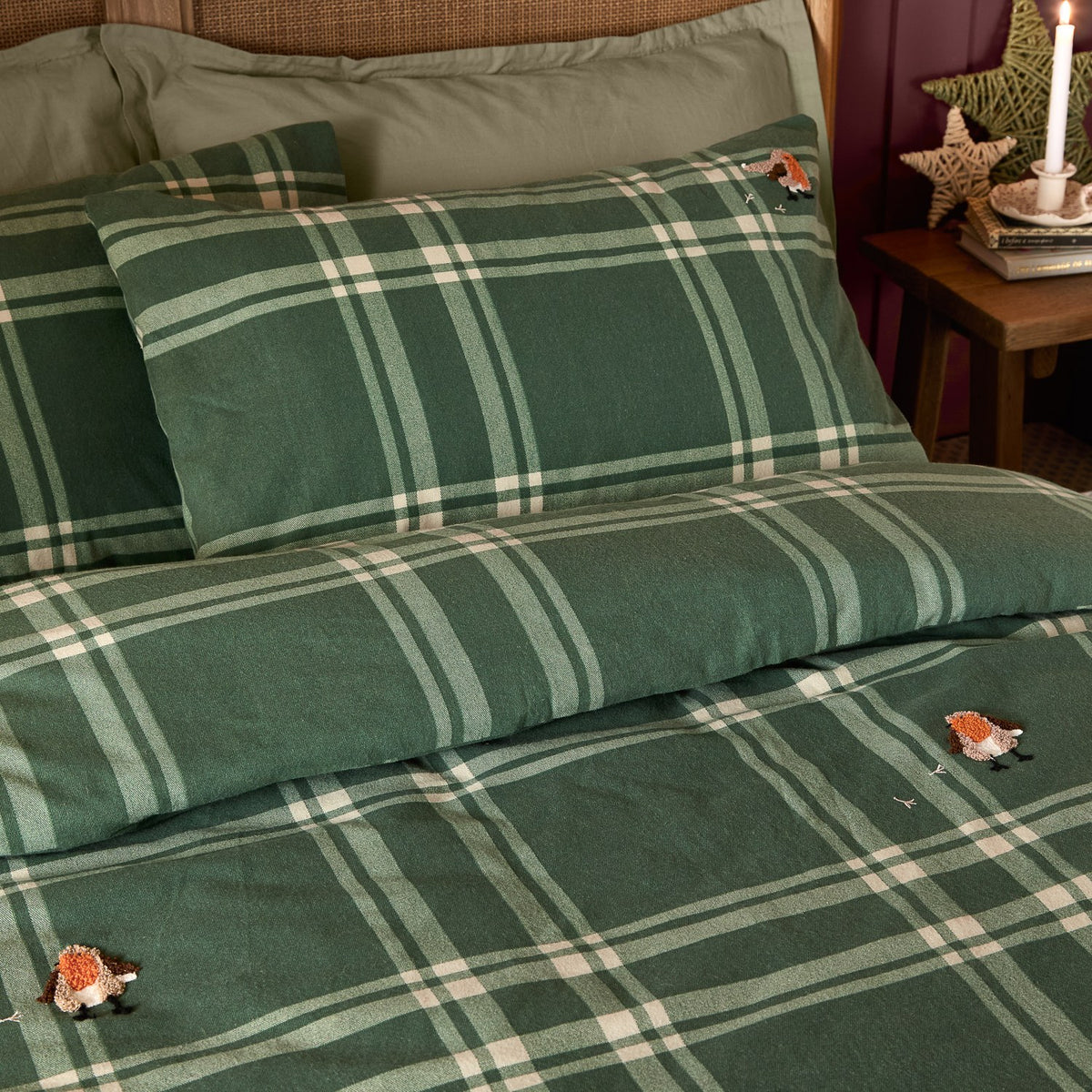 Ramble Cotton Check Duvet Cover Set in green, styled on a bed with matching pillowcases in a green plaid pattern featuring small embroidered bird motifs.