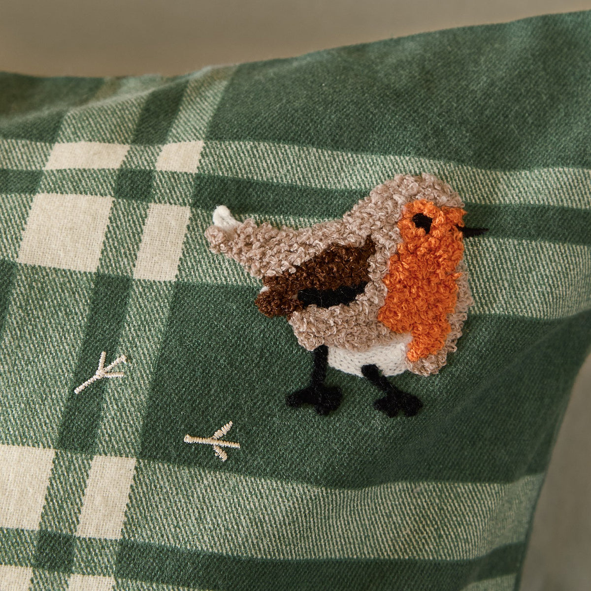 Close-up of the Ramble Cotton Check Duvet Cover Set in green, showing brushed cotton plaid fabric with an embroidered robin bird motif in orange, brown, and cream thread.
