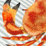 Close-up of the Salcombe Crab velvet cushion, showing a hand-painted orange and rust crab with dark-tipped claws on a grey-blue and white striped ground.