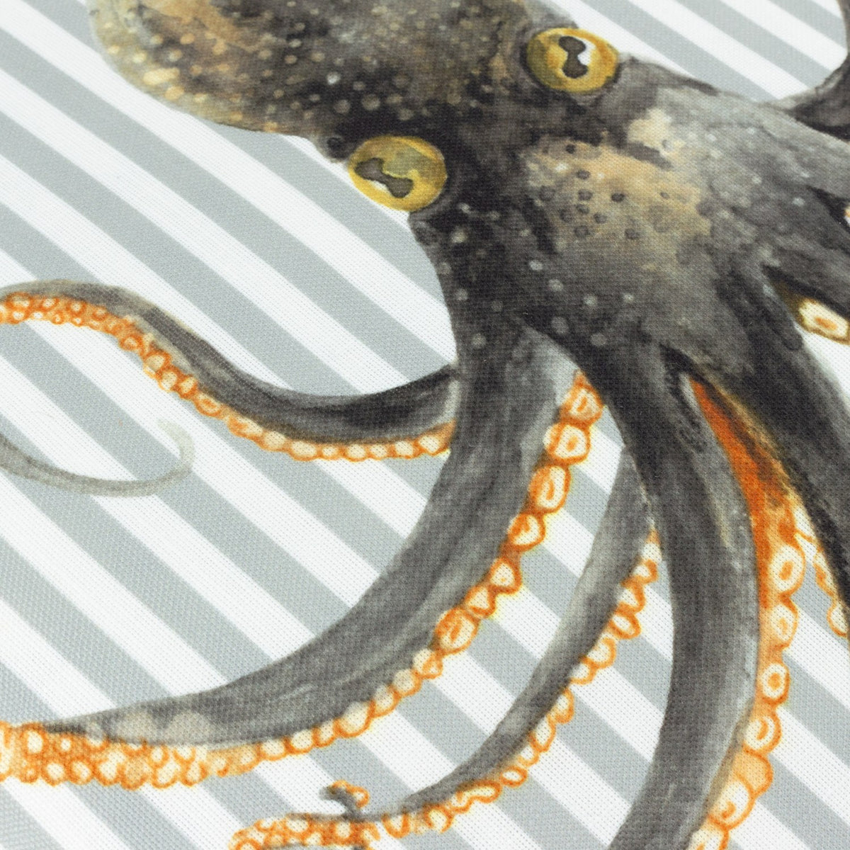 Close-up of the Salcombe Octopus velvet cushion showing a hand-painted charcoal octopus with amber eyes and suckers against grey-blue and white striped fabric.