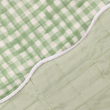 Close-up of the Scallop Plain Cotton Blend Bedspread in Sage, showing the reversible sage gingham check and plain quilted sides joined by a white piped scalloped edge.