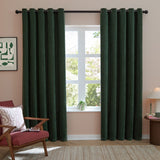 Soft chenille eyelet curtains in bottle green hang floor-length either side of a window with black rod, styled in a living room with pink walls and armchair.