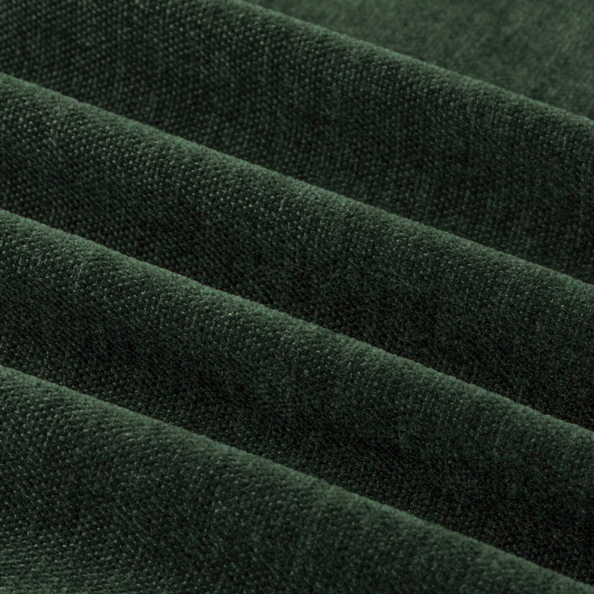 Close-up of soft chenille fabric in bottle green, showing pile yarn texture and eyelet curtain folds with a matt, velvety surface.