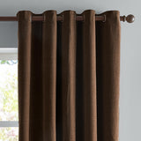 Chocolate brown chenille eyelet curtains hanging on a dark metal pole, showing grommet header and textured woven fabric against a light grey wall.