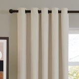Soft chenille eyelet curtains in ecru, shown hanging from a dark metal rod on grommet fittings beside a window in a living room setting.