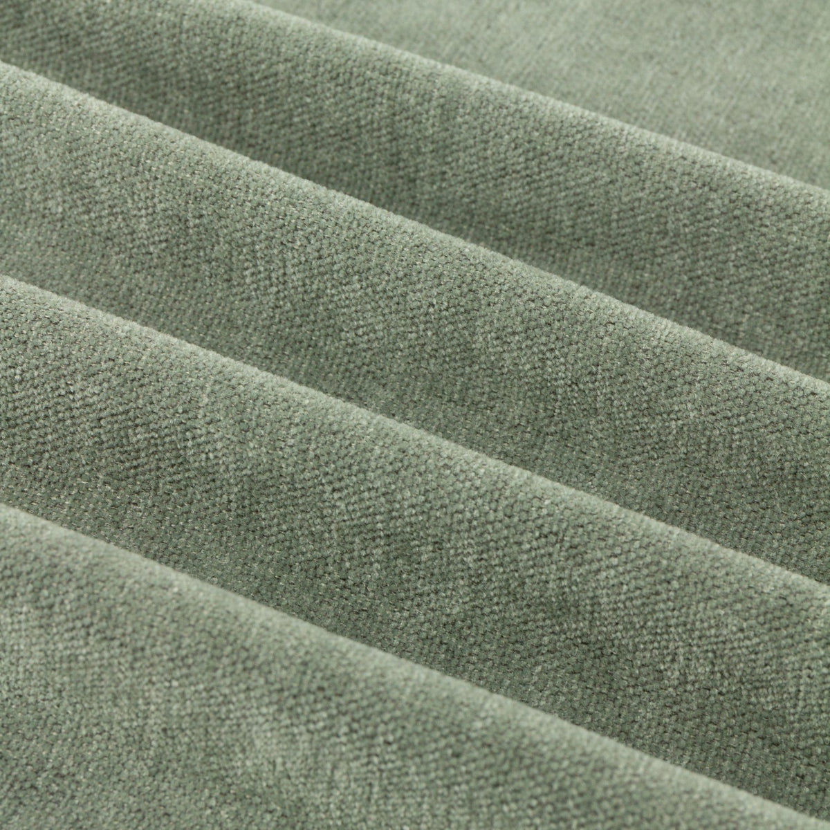 Close-up of soft chenille fabric in muted green, showing the plain woven texture and matt surface of the Eyelet Curtains.