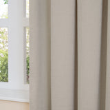 Close-up of Soft Chenille Plain Lined Eyelet Curtains in natural oatmeal beige, showing hanging folds beside a white-framed window overlooking greenery.