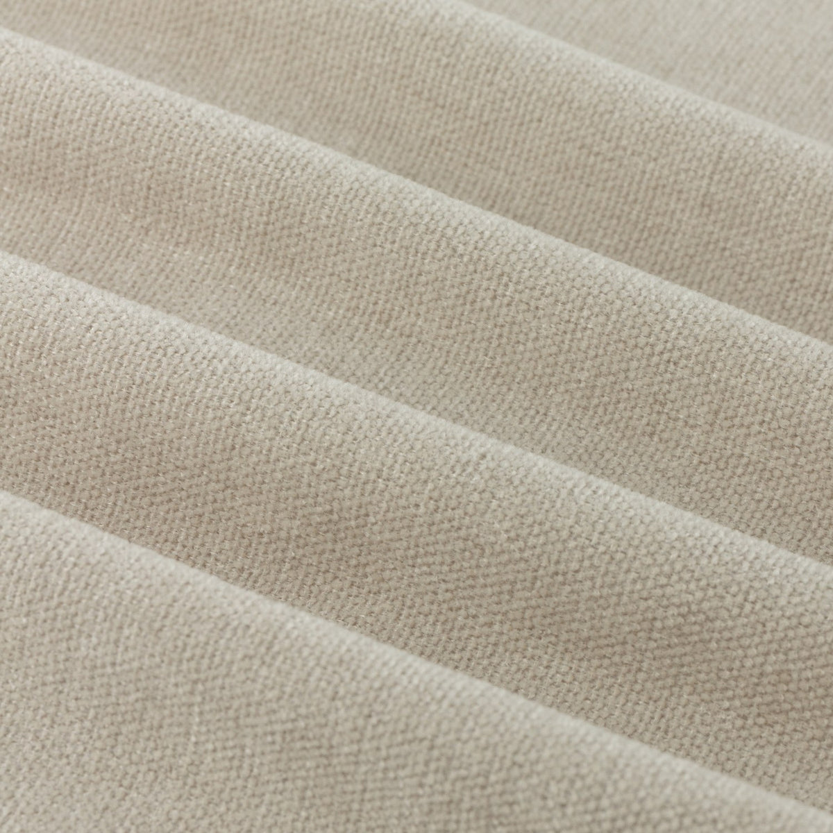 Close-up of Soft Chenille Plain Lined Eyelet Curtains in natural oatmeal beige, showing the folded fabric's dense woven pile and matt finish.
