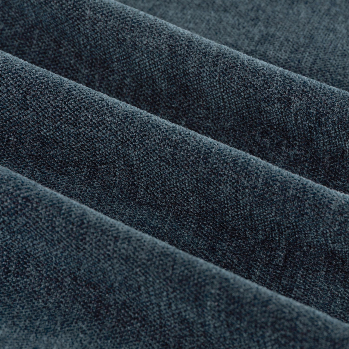 Close-up of Soft Chenille Plain Lined Eyelet Curtains in navy, showing folded fabric with a matte, velvety woven texture in deep blue.