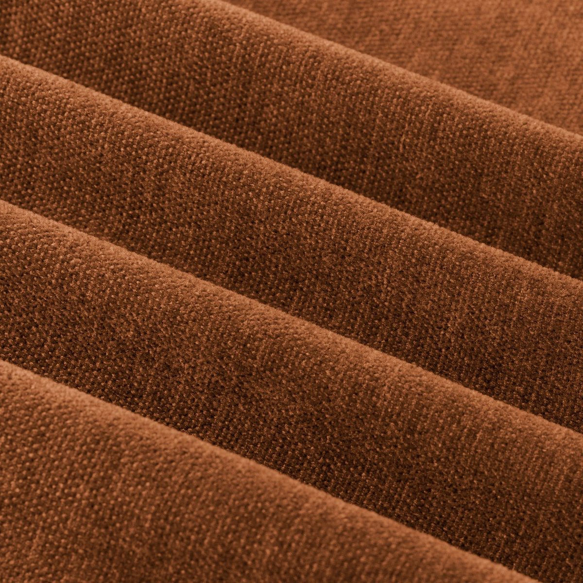 Close-up of soft chenille eyelet curtain fabric in rust, showing the woven texture and folds of the lined material.