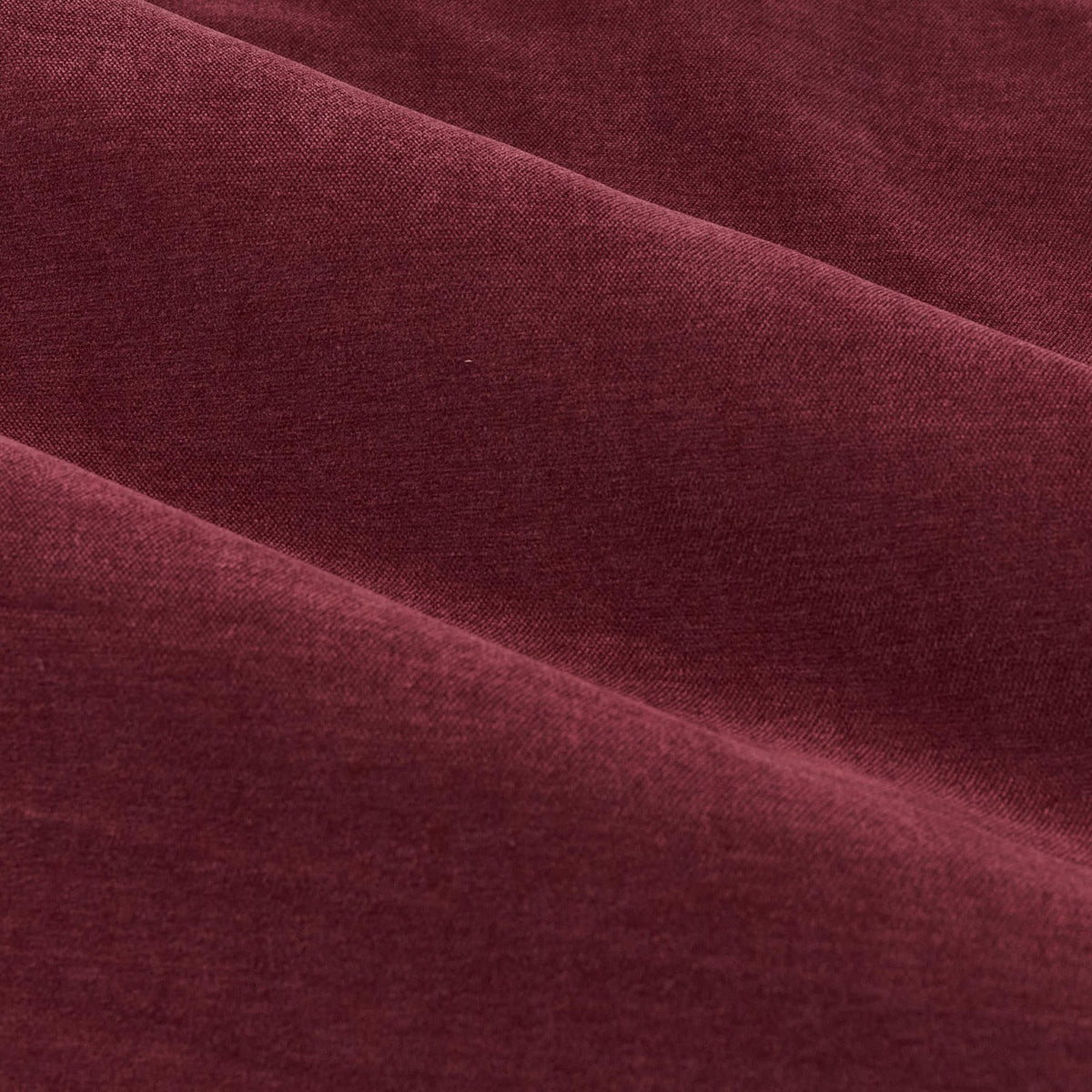 Close-up of soft chenille fabric in deep beetroot red with a gently heathered, matt texture, from the Pencil Pleat Curtains showing folds and draped layers.