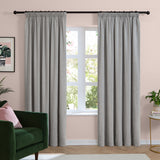 Silver-grey chenille pencil pleat curtains with pencil-pleat heading on a black pole, shown either side of a window in a living room with pink walls.