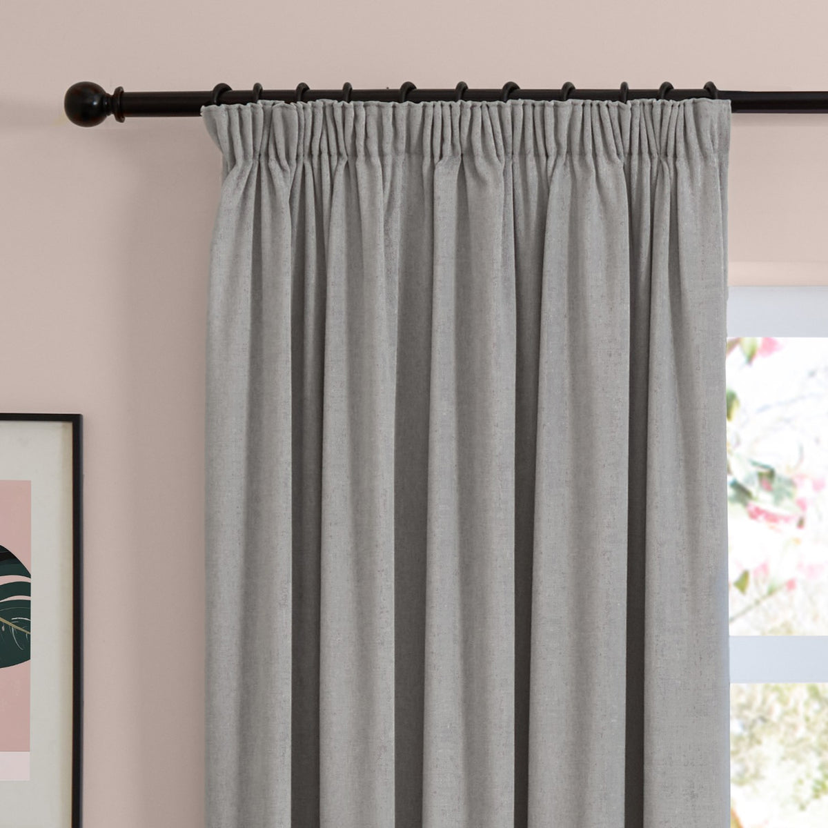 Silver-grey chenille pencil pleat curtains with pinch-pleated heading on a black pole, hung in a bedroom against a soft pink wall.
