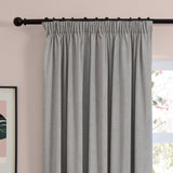 Silver-grey chenille pencil pleat curtains with pinch-pleated heading on a black pole, hung in a bedroom against a soft pink wall.