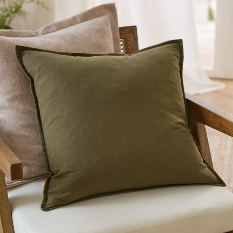 Slub Cotton Woven Plain Cushion in Lichen olive green with a flanged edge, styled on an armchair with a beige cushion and wooden frame.