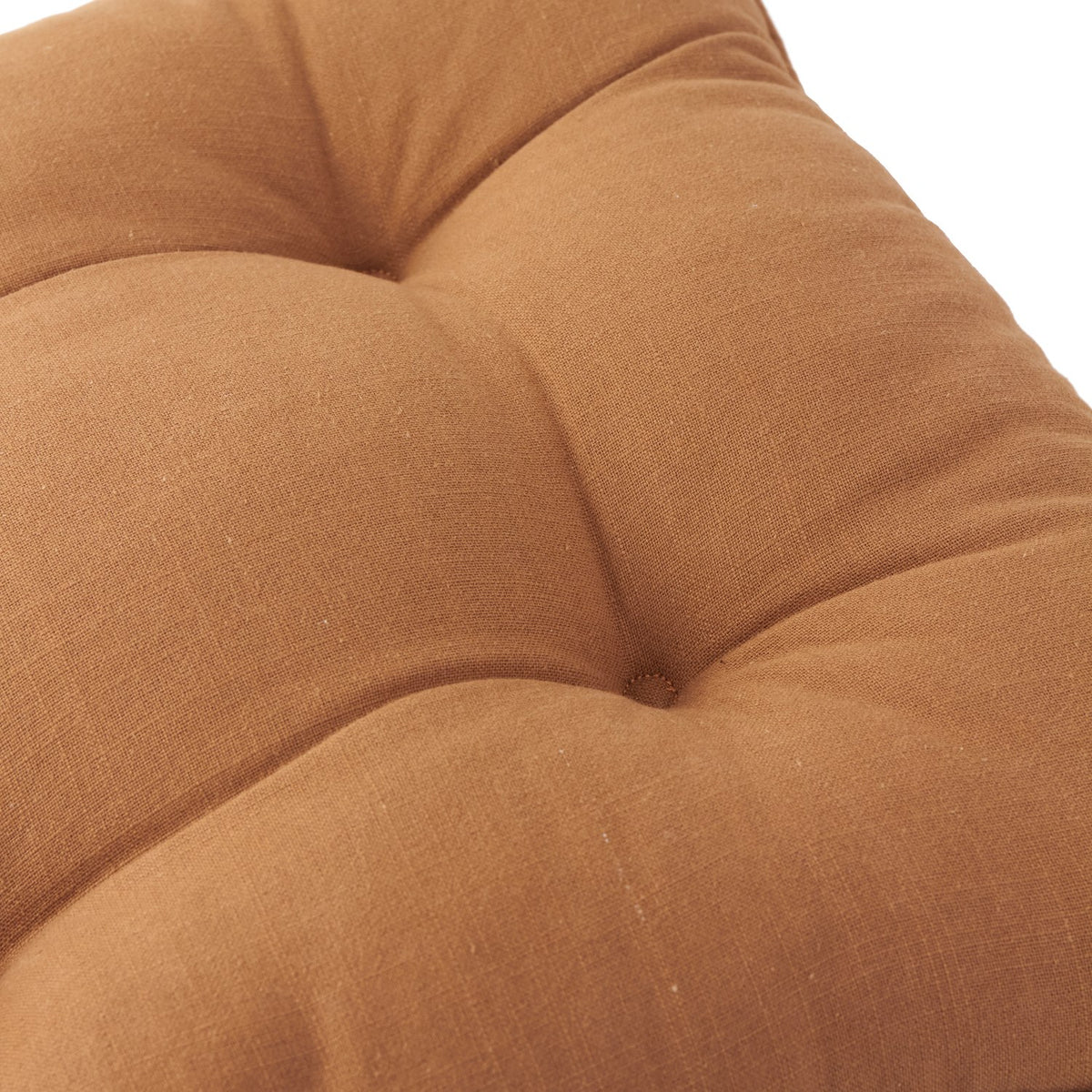 Close-up of a toffee brown slub cotton seat pad showing tufted button detailing and the fabric's natural, unevenly textured weave.