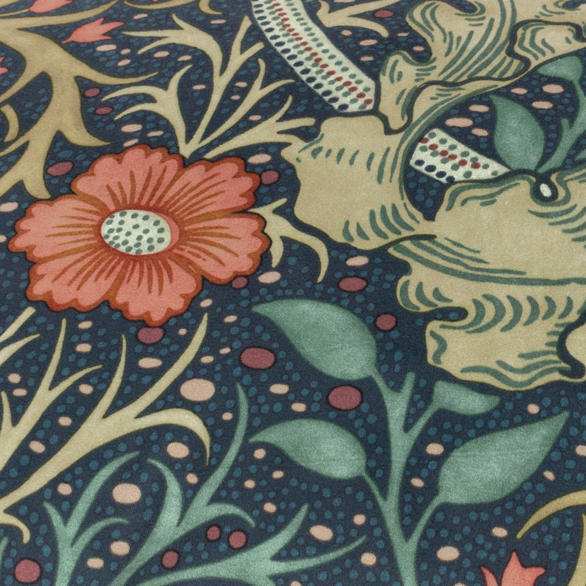 Close-up of the Seaweed Floral Velvet Cushion in indigo, showing coral-red flowers, green leaves and stems printed on dotted deep blue velvet fabric.