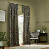 Seaweed pencil pleat curtains in indigo velvet with a trailing floral pattern, pencil pleat heading on a black rod in a living room setting.