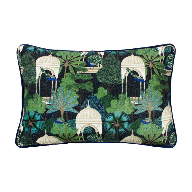 Rectangular cotton velvet cushion in Midnight, featuring a printed tropical garden scene of peacocks, palms and pale domed pavilions in green and blue on black, shown on a white background.