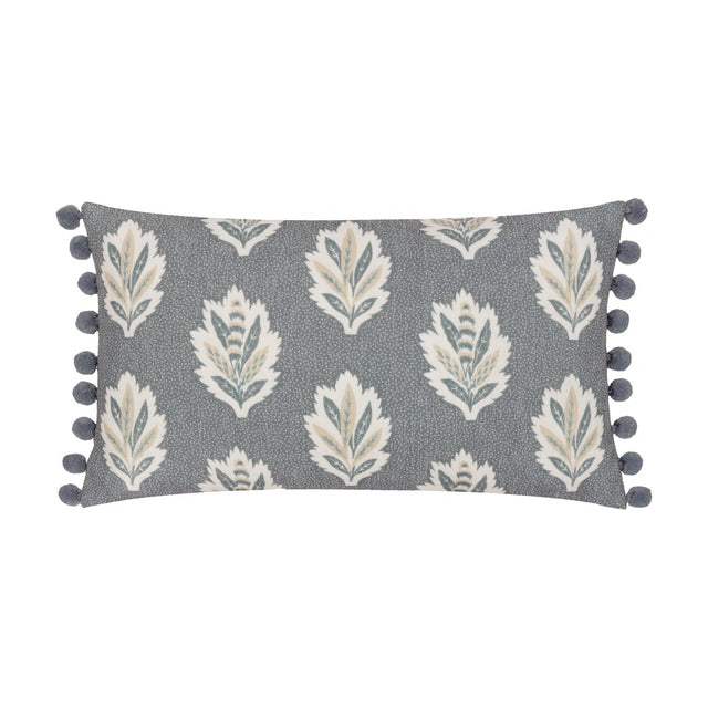 Sessile Leaf Reversible Cotton Cushion in Delph Blue, rectangular with cream, teal and gold leaf print on a blue-grey ground, edged with blue pom-pom trim, on a white background.