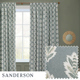 Sessile Leaf pencil pleat curtains in Delph Blue, pinch-pleated polyester panels with a leaf motif, shown at a window beside a fabric swatch and round mirror in a green-toned room.