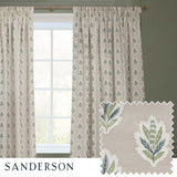 Pencil pleat curtains in flax-beige with a repeating Sessile Leaf motif in green and slate blue, shown pencil-pleat headed on a wooden pole beside a window, with a fabric swatch inset.