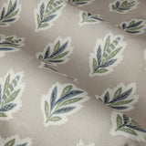 Sessile Leaf Floral pencil pleat curtain fabric in flax-beige, showing a repeat pattern of stylised oak-leaf motifs in green and slate blue on a spotted ground.