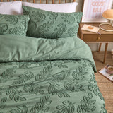 Seville Leaf Tufted Floral Duvet Cover Set in green, showing tone-on-tone chenille-style leaf tufting on duvet and pillowcases, styled on a bed in a bedroom setting.