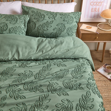 Seville Leaf Tufted Floral Duvet Cover Set in green, showing tone-on-tone chenille-style leaf tufting on duvet and pillowcases, styled on a bed in a bedroom setting.