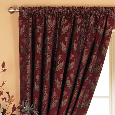 Shiraz Jacquard Chenille pencil pleat curtains in burgundy with a gold and green floral damask pattern, shown hanging on a pole in a room setting.