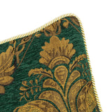 Close-up of the Shiraz Jacquard Chenille Cushion in emerald, showing a gold floral damask weave with a twisted cord edge trim, against a white background.