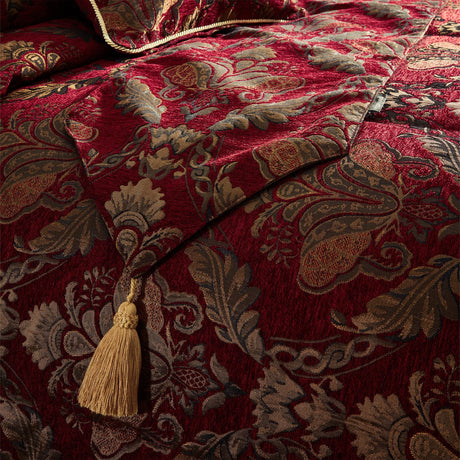 Shiraz Cotton Chenille Bed Linen in burgundy, showing a jacquard floral damask pattern in gold on a chenille-textured bedspread with a matching gold tassel accent.