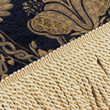 Close-up of the Shiraz Jacquard Chenille Throw in black, showing gold floral damask weave alongside a knotted cream fringe trim.