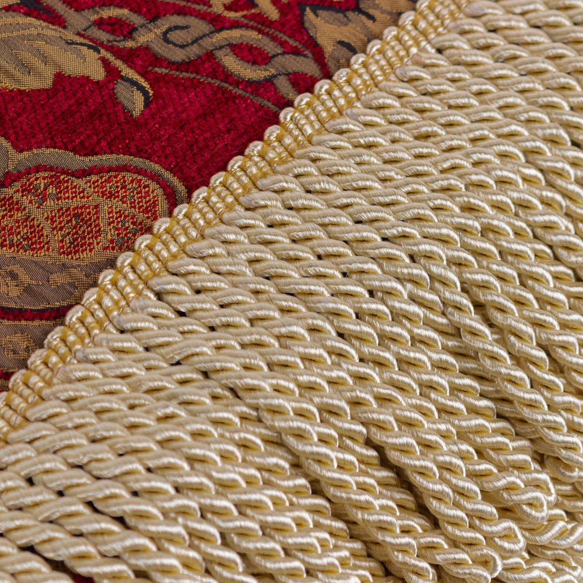 Close-up of the Shiraz Jacquard Chenille Throw in burgundy, showing gold floral damask chenille fabric edged with a twisted gold fringe.