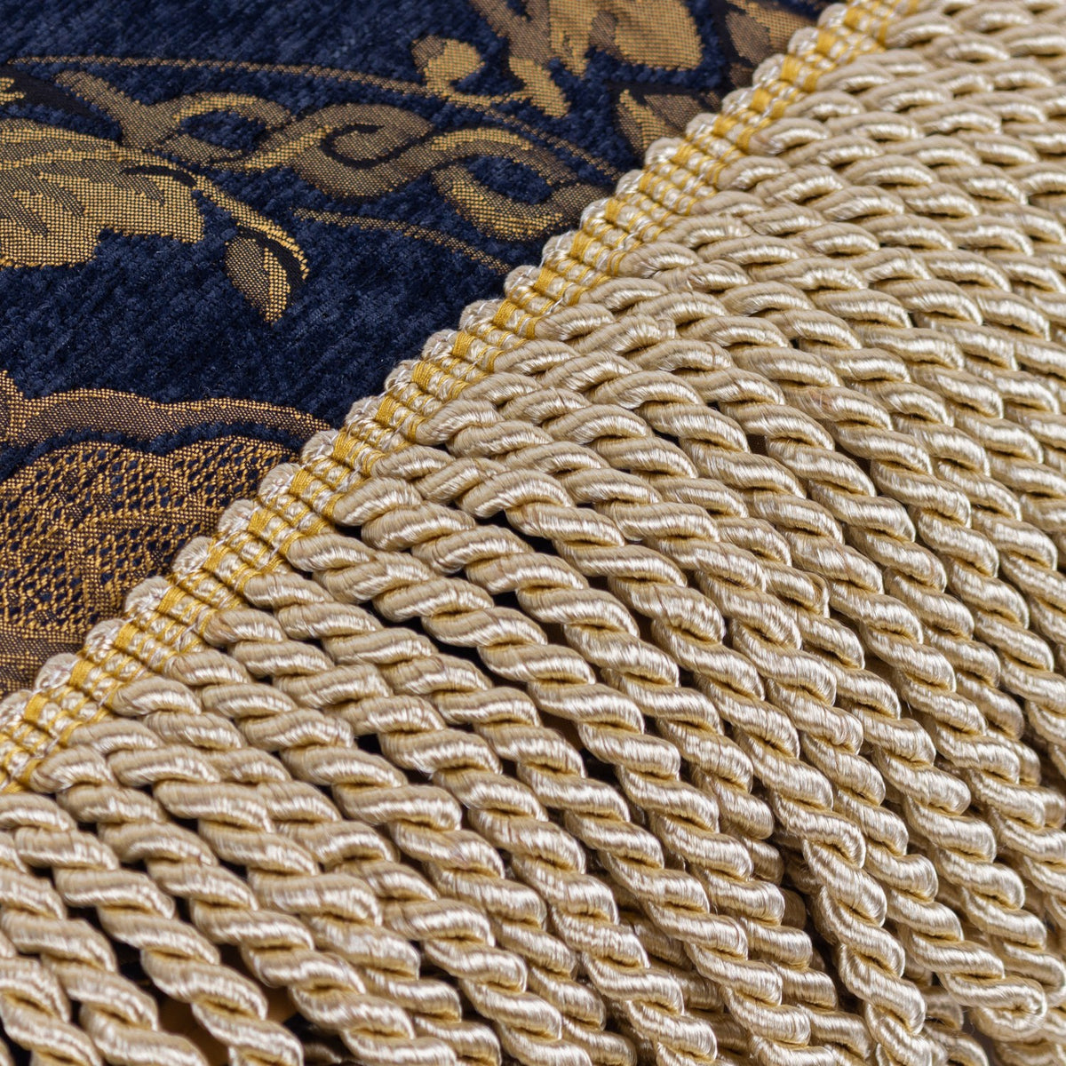 Close-up of the Shiraz Polyester Throw in navy, showing gold damask jacquard weave with a bullion fringe trim along one edge.