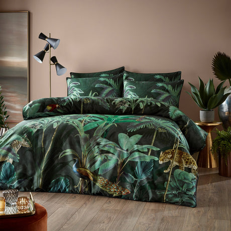 Siona Cotton Jungle Duvet Cover Set with matching pillowcases in a dark green tropical print featuring peacock, leopard, zebra and macaw motifs, shown on a bed in a bedroom setting.