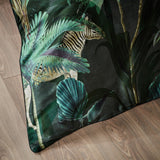 Siona Cotton Jungle Duvet Cover corner, dark green cotton fabric printed with palm leaves and a zebra, shown angled on a wooden floor.