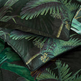 Siona Cotton Jungle Duvet Cover Set featuring dark green tropical palm print with pillowcases in matching foliage design and satin piping edge detail.